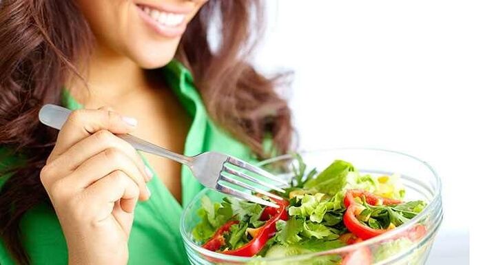 meitene ēd dārzeņu salātus, ievērojot olbaltumvielu diētu